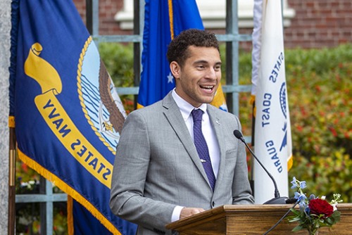 Terren Wise stands in a suit and tie behind a podium at a Veterans Day ceremony