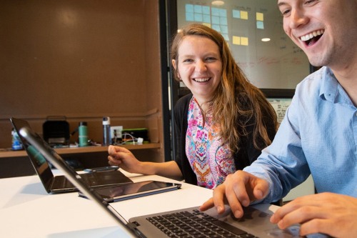 Abbie smiles as she sits over a laptop computer