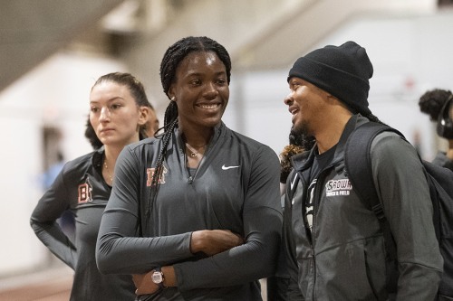 Chiamaka talks with teammates while standing near the indoor track at OMAC